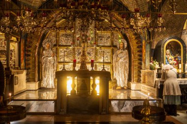 Kudüs, İsrail, 22 Aralık 2025, Kutsal Mezar Kilisesi, sunak alanı gümüş ikon paneller ve zengin dekore edilmiş bir tapınakta sıcak mum ışığı..