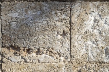 İsrail 'deki eski, yıpranmış kireçtaşı duvar dokusunun yakın çekimi.