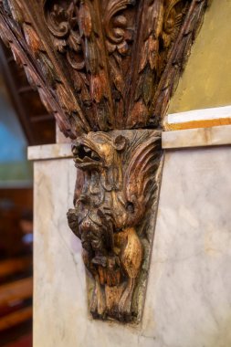 Nasıra, İsrail, 24 Aralık 2025, Yunan Ortodoks Kilisesi. Mermer bir sütunda destek görevi gören oyma ahşap bir Griffin figürünü kapat.