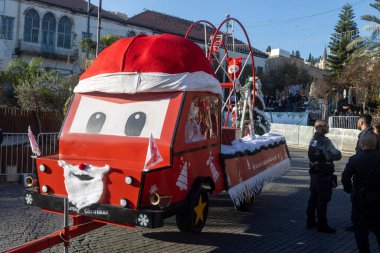Nasıra, İsrail, 24 Aralık 2025 Noel kutlamaları sırasında Nasıra sokaklarında gezen yüzü ve Noel şapkası olan bir karikatür kamyonu gibi tasarlanmış kırmızı bir geçit töreni..