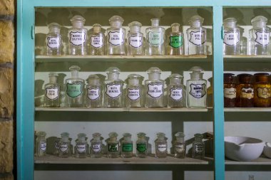Raflar antika cam eczane şişeleriyle dolu. Tarihi bir eczane ortamında orijinal kimyasallar var..
