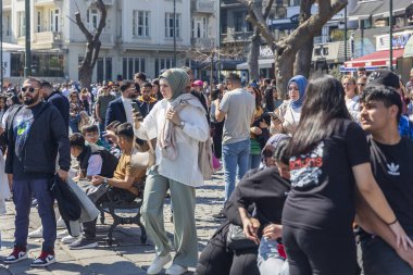 İstanbul, Türkiye, 5 Mayıs 2025: İstanbul, Türkiye 'deki Ortakoy Camii önünde açık mavi gökyüzü altında sokak satıcıları ve çıplak ağaçlarla büyük bir kalabalık toplandı