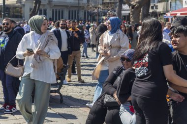 İstanbul, Türkiye, 5 Mayıs 2025, İstanbul, Türkiye 'de kalabalık bir liman meydanı, güneşli bir günde Ortakoy Camii ve Boğaz Köprüsü yakınlarında yürüyen kalabalık