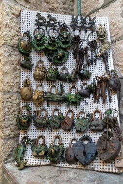 Hayvan şeklinde dekoratif metal kilitler ve bir antikacıda beyaz bir tahta üzerinde gösterilen semboller..