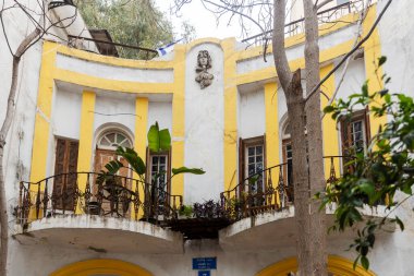 Tel Aviv, İsrail, 15 Şubat 2026, kavisli camları ve dekoratif kadın göğüs heykeli olan tarihi bir binanın ön cephesi.