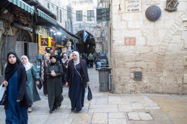 Kudüs, İsrail, 15 Şubat 2026, Via Dolorosa caddesinde yürüyen bir grup kadın taş duvarda tarihi işaretlerle