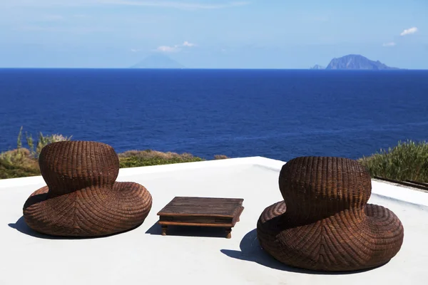 Para leżaki i whisky baryłkę tabela zapewnia idealne miejsce do połowu wygrzewał w słońcu na plaży — Zdjęcie stockowe
