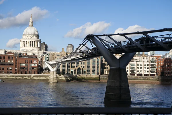 Menschen überqueren die Millenniumsbrücke über die Themse, die die Stadt London mit dem Südufer verbindet — Stockfoto