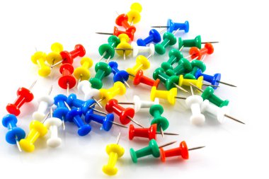 Beyaz arkaplanda renkli itme iğneleri.