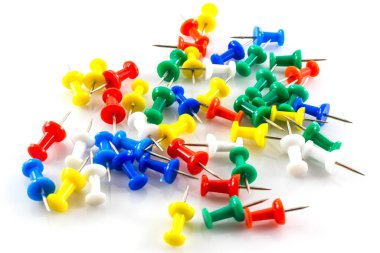 Beyaz arkaplanda renkli itme iğneleri.