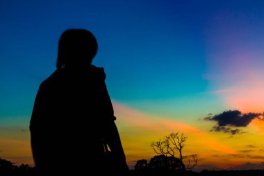 Gün batımı geçmişi olan siluet fotoğrafçı.