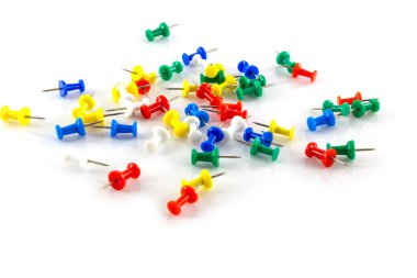 Beyaz arkaplanda renkli itme iğneleri.