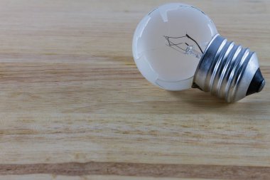 Ahşap arka planda kırık ampul.