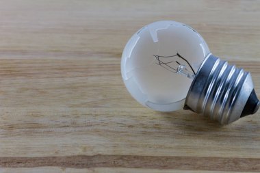 Ahşap arka planda kırık ampul.