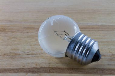 Ahşap arka planda kırık ampul.