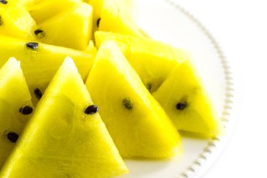 Beyaz zemin üzerinde sarı karpuz dilimleri