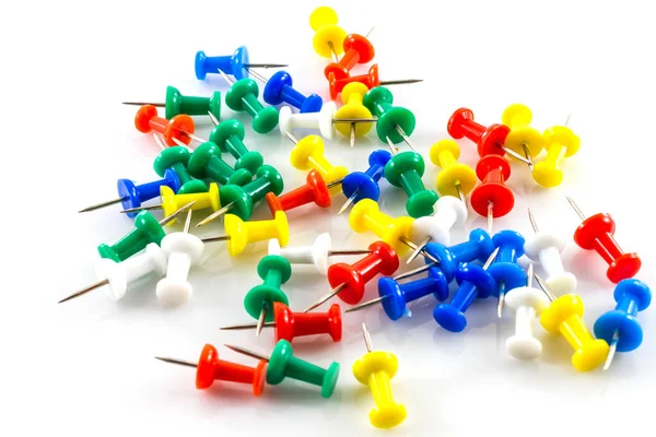 Beyaz arkaplanda renkli itme iğneleri.