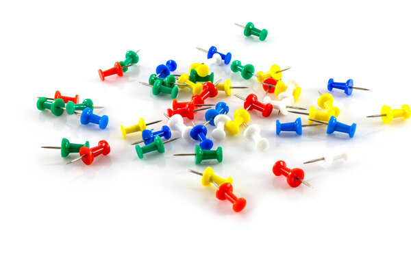 colorful push pins on white background.