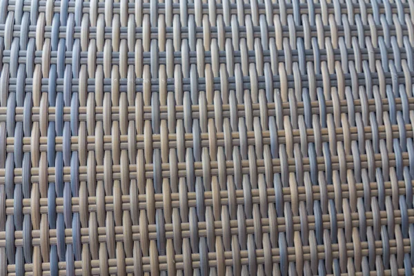 Sentetik rattan dokuma arka planı bahçe mobilyalarında kullanılıyor..