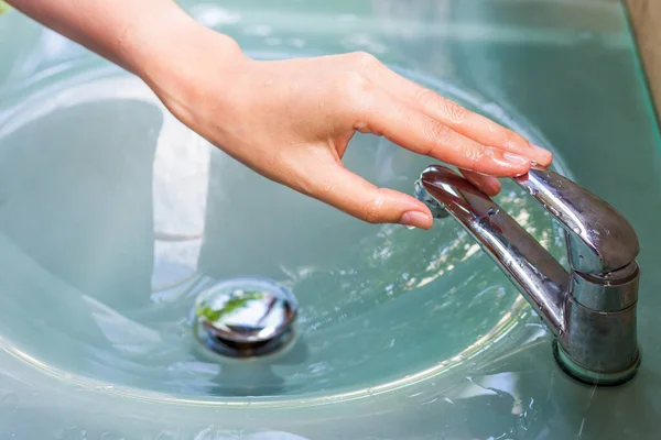 girl washing her hand and turn off faucet out door