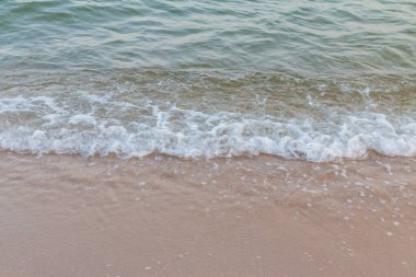 Okyanusta dalgalar ve kumsalda kumlar