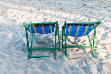 Plaj arka planında tahta plaj sandalyesi.