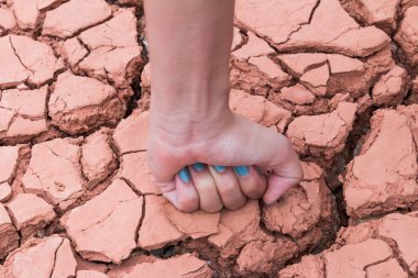 Yumruk eller kuru toprağa ya da çatlak yeryüzüne.