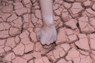 Yumruk eller kuru toprağa ya da çatlak yeryüzüne.