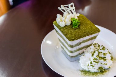 Yeşil çay tiramisusu, yeşil çay tozu ve nane yaprağı.