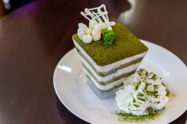 Yeşil çay tiramisusu, yeşil çay tozu ve nane yaprağı.