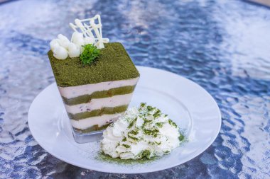 Yeşil çay tiramisusu, yeşil çay tozu ve nane yaprağı.