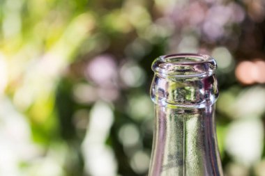 Yeşil bokeh arka planda cam şişe