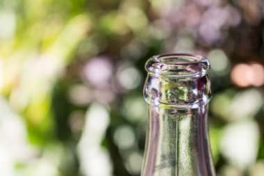 Yeşil bokeh arka planda cam şişe