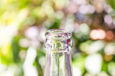 Yeşil bokeh arka planda cam şişe