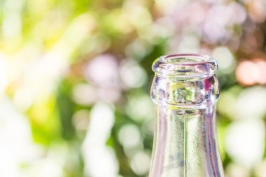 Yeşil bokeh arka planda cam şişe