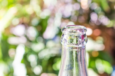 Yeşil bokeh arka planda cam şişe