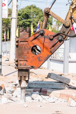 Makine pnömatik çekiç matkabı sıcak bir günde yolda asfalt betonu kırıyor.