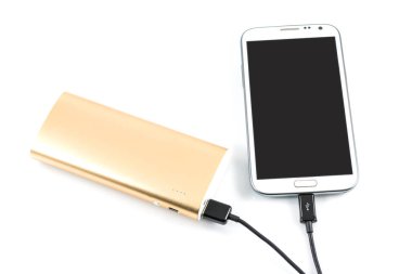 Altın güç bankası beyaz arkaplanda beyaz akıllı telefonu şarj ediyor