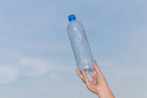 Tangan Memegang Botol Air Minum Latar Langit Biru — Stok Foto