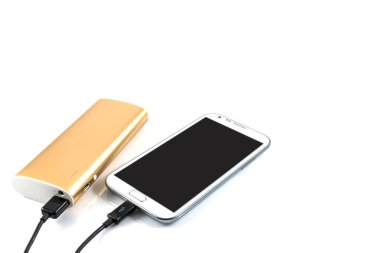 Altın güç bankası beyaz arkaplanda beyaz akıllı telefonu şarj ediyor