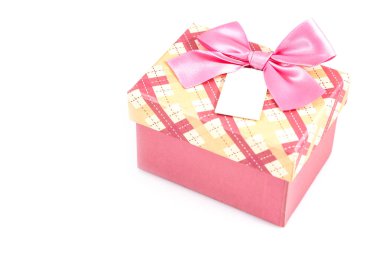 Beyaz arka planda pembe fiyonklu ve beyaz etiketli pembe Noel hediyesi kutusu