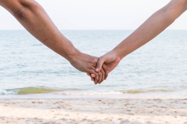 Aşıklar kumsalda el ele tutuşur, eski usul.