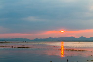 Nehrin üzerinde gün batımı ve çok uzaktaki dağ