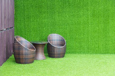 Yeşil arka planda kahverengi hasır sandalye