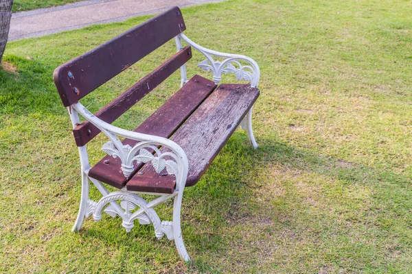 White chair in the park on green grass background