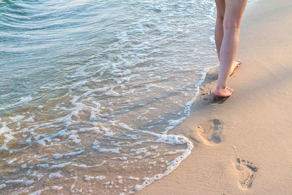 Yalnız Kız Dalgalı Ayak Izleriyle Kumda Yürüyor — Stok fotoğraf
