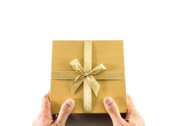 El, beyaz arka planda altın yay ile altın hediye kutusu