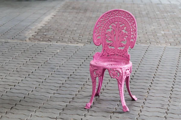 Pink metal vintage chair on brick floor