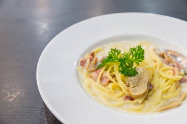 Spagetti, peynir, pastırma ve mantarlar beyaz diskte