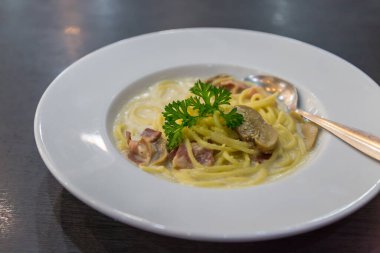Spagetti, peynir, pastırma ve mantarlar beyaz diskte